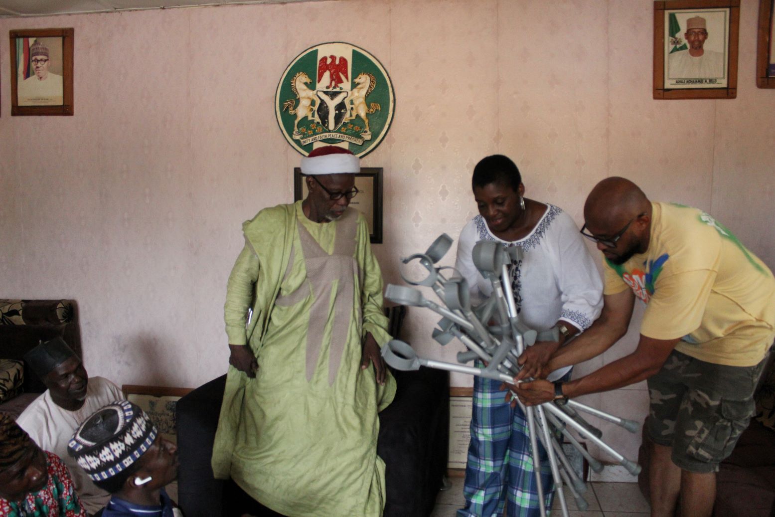 The chief of the colony being presented with some of the crutches by PADIN